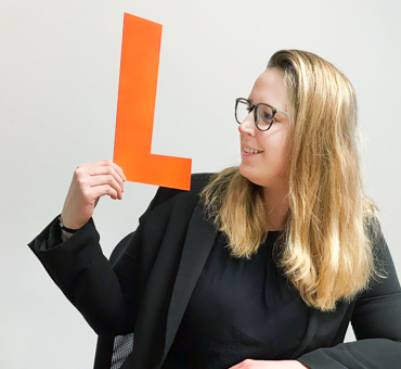 IDEAL_Stefanie_Groebe Person mit einem gebastelten Buchstaben L aus Pappe in der Hand.